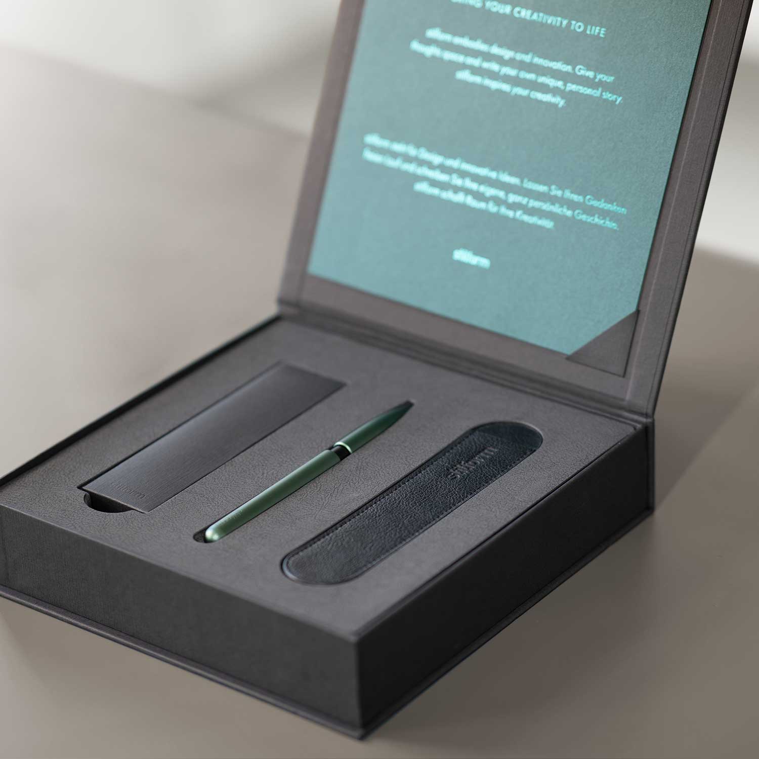 Geschenkbox mit Aluminium Kugelschreiber Pen in Aurora Green, Etui und Ersatzminen auf grauem Untergrund