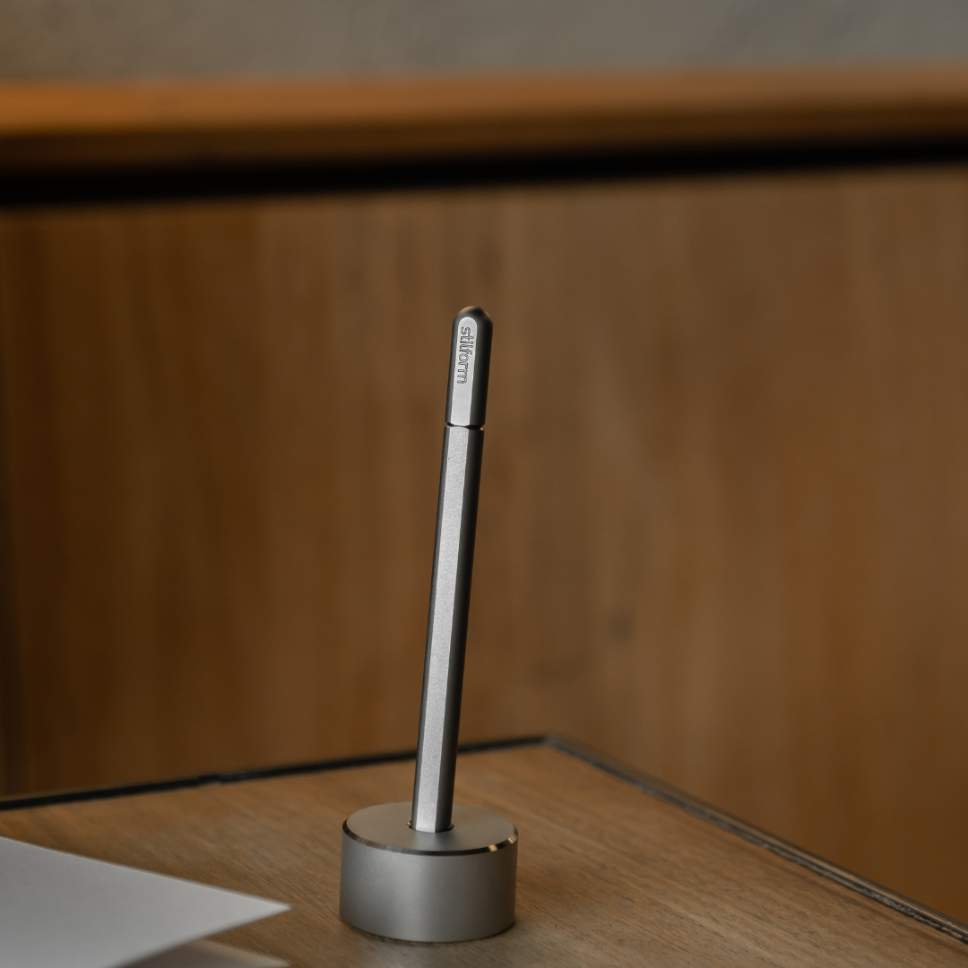 Stifthalter Base aus Titan mit Gelstift Titan Matt auf Holzoberfläche inszeniert